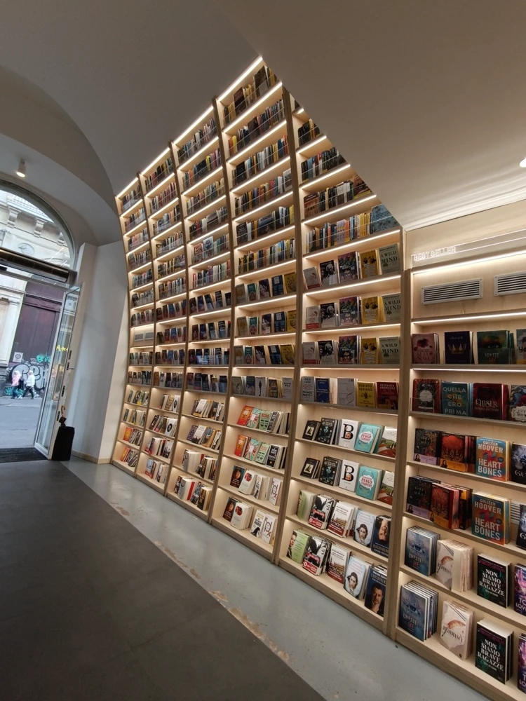 Mur de librairie du sol au plafond, étagères éclairées.