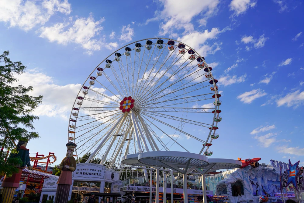 Grande roue blanche du Prater sous un ciel de nuages, fête foraine.